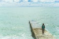 SOCHI,RUSSIA, 20 APRIL 2019 - lonely young girl standing on the breakwater back to the camera and looking at the sea