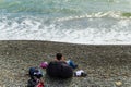 SOCHI,RUSSIA, 20 APRIL 2019 - lonely young nan sitting back to the camera on the beach and looking at the sea