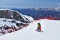 Sochi, Russia - April 1, 2014: Young couple stands embracing on ski track in Gorky Gorod mountain ski resort on snowy Caucasus Royalty Free Stock Photo