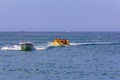 Happy vacationers tourists ride an inflatable banana in the sea in summer