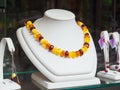 Necklace and silver earrings with amber on the showcase of a jewelry store