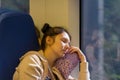 The sleeping young woman riding in high-speed electric train Lastochka in the summer