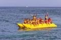 Vacationers tourists ride an inflatable banana in the sea on a hot summer day