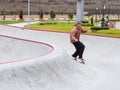 Sochi, Russia - 26 December 2019. A guy in a grey hat and plaid shirt rides a skateboard bending his legs preparing for