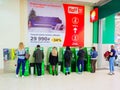 Sochi, Russia - 14 December 2019. People stand at green ATM machines against wall background with large advertising