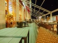 Sochi, Russia - 26 December 2019. Tables and wicker chairs stand on the terrace of an outdoor summer cafe in the evening Royalty Free Stock Photo