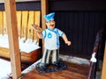 Sochi, Russia - 25 February 2020. A figurine of a chef holding a pizza stands on a wooden floor near a bench covered