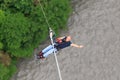 Man with go pro camera on his wrist is about to jump 207 meter bungy at AJ Hackett Sky Park on mountain forest background. Extreme