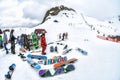 Sochi, Russia - March 28, 2014: Skiers and snowboarders relax in snowy mountains with boards resting on the snow. Scenic winter