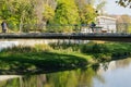 Beautiful autumn view of Sochi river with reflection of sky in water. River embankment with building and pedestrian bridge. Royalty Free Stock Photo