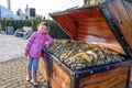 Small Caucasian girl standis beside artificial chest full of gold treasures in Sochi Park which is biggest and most amazing