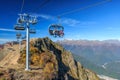 People ride on chair ski lift of Gorky Gorod mountain resort in autumn in Caucasus mountains. Sochi Royalty Free Stock Photo