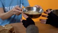 Social activist giving soup bowl homeless female, charity food in shelter, help