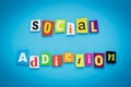 Social addiction. A word writing text of cut letters on a blue background. Headline, card, banner with inscription. Psychological