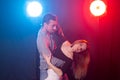 Social dance, bachata, salsa, kizomba, zouk and tango concept - Man hugs woman while dancing over lights Royalty Free Stock Photo