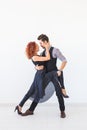 Social dance, bachata, kizomba, zouk, tango concept - Man hugs woman while dancing over white background in studio Royalty Free Stock Photo