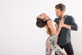 Social dance, bachata, salsa, kizomba, zouk, tango concept - Man hugs woman while dancing over white background with