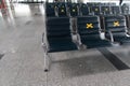 Social distance at the airport. Airport seats with a sign are prohibited. Empty seats in an international airport lounge Royalty Free Stock Photo