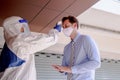 Social distance concept. Officer wearing a respirator mask to use infrared forehead thermometer to check fever body temperature Royalty Free Stock Photo