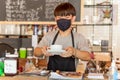 Social distance conceptual small business waiter serving coffee to customer in cafe. Royalty Free Stock Photo