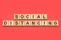 Social distance. The inscription on wooden blocks on a red background.