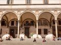 Social distance of people of italian city on sunny day under historical house arches