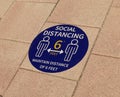 Social distance sign enamel painted with stencil on the floor