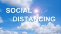 Social distancing cloud text on blue sky with lens flare Royalty Free Stock Photo