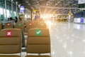 Social distancing concept. Correct and cross symbol on seat at waiting area of airport terminal