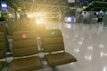 Social distancing concept. Correct and cross symbol on seat at waiting area of airport terminal