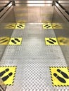 Social distancing for COVID-19 coronavirus crisis prevention with yellow footprint sign text caution to respect social distance