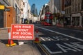 Social Distancing new road layout sign with London Double Decker Bus and St Paul`s Cathedral in the background during Covid 19