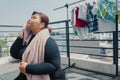 Plus size young asian woman use towel wipe the sweat after doing exercise on mat in balcony, going to loose extra pounds at home,