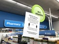 Social distancing sign at pharmacy store requesting customers to practice a safe distance of at least 6 feet while waiting for