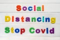 Social Distancing stop covid Sign & Symbol, plastic letter on white wood background