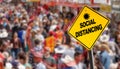 Social distancing warning sign with prohibition symbol over a crowd