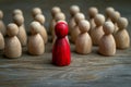 Social dynamics red wooden doll surrounded, conveying discussions or leadership