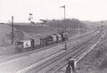 Vintage black and white photo of a static line of train carriages and wagons on track 1950s