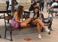 Social life - two young pretty girls sitting on a bench