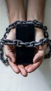 Social media addiction Chained hands with a mobile phone