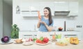 Social media concept. Happy woman standing in kitchen, using camera and recording online video. Happy asian woman vlogger broadcas