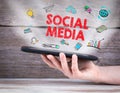 Social Media concept. Tablet computer in the hand. Old wooden background Royalty Free Stock Photo