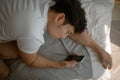 Social media depression. Sad and depressed man lie on the sofa with mobile phone. Royalty Free Stock Photo