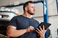 Social media helps me to grow my reputation as a reliable and trusted auto mechanic. a mechanic using a digital tablet