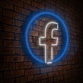 Facebook icon with a form neon lamp hanging in the wall