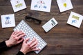 Social media promotion. Work desk with socail media icons. Dark wooden background top view. Hand is typing