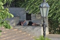 A homeless sleeps in a city centre square.