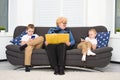 A social problem.	Grandmother reads a book to children, and they play on mobile phones. Royalty Free Stock Photo
