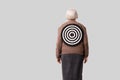 Social problems of the elderly idea. Target on the back of an old woman. Royalty Free Stock Photo