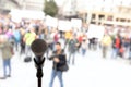 Social protest or public demonstration. Microphone in focus against unrecognizable crowd of people